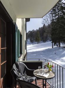 a patio with a table and chairs on a balcony at Bad Serneus Water Resort in Klosters