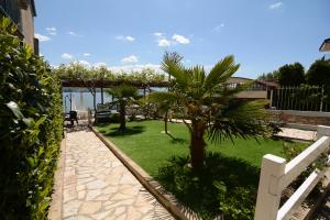 a garden with palm trees and a white fence at Apartment Bojadzi in Ohrid