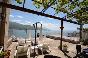 eine Terrasse mit Stühlen und Blick auf das Wasser in der Unterkunft Apartment Bojadzi in Ohrid