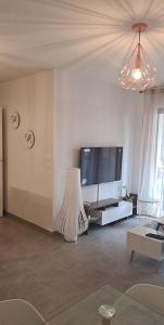 a living room with a flat screen tv and a couch at Appartement cosy de 2 chambres in Montpellier