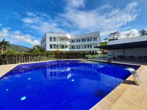 a large swimming pool in front of a house at Hotel Palmeras De Luz in Moniquirá