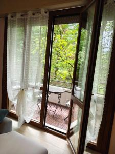una camera con porta scorrevole in vetro con tavolo esterno di Beb Casa-La Lucciola a Salsomaggiore Terme