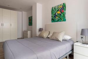 a white bedroom with a large bed with two pillows at Garden Turia Downtown in Valencia