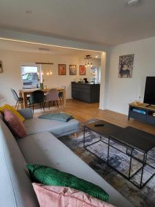 ein Wohnzimmer mit einem Sofa und einem Tisch in der Unterkunft ALA-Living Familien-Glück für 8 Personen Legoland in 4min in Günzburg