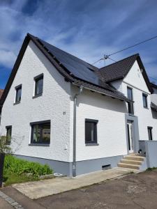 una casa blanca con techo negro en tolles Familienhaus für 8 Personen - 4min zum Legoland!, en Günzburg