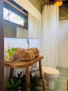 uma casa de banho com WC e uma pedra sobre uma mesa em Quintal da Cuiarana - 50M da praia principal de Alter do Chão em Alter do Chão
