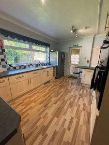 a kitchen with a hard wood floor and a table at A Stunning 3 bed family Home - Woodcote House in Carshalton