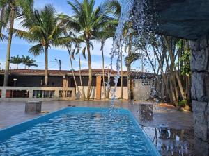 a swimming pool with a water fountain at Casarão Pertinho da Praia in Bertioga