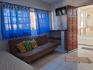a living room with a couch and blue curtains at Casarão Pertinho da Praia in Bertioga