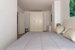 a large white bed in a white bedroom at Garden Turia Downtown in Valencia