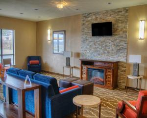 a living room with a couch and a fireplace at Comfort Suites Plymouth near US-30 in Plymouth