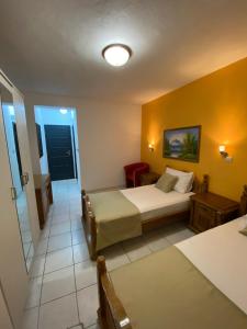 Hotel Kuč في بودفا: غرفة نوم بسرير وجدار اصفر