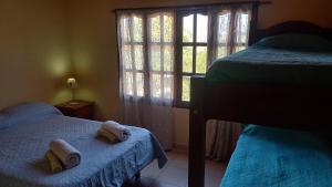 sypialnia z 2 łóżkami i oknem w obiekcie La Rosarito w mieście Humahuaca