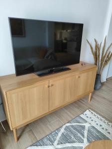 a large flat screen tv on a wooden entertainment center at Eva's Suite in Serres +9 photos