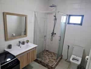 a bathroom with a sink and a shower with a glass door at Blissful Abode GV in Grand Gaube