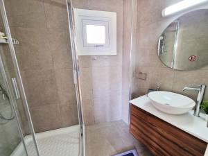 a bathroom with a shower and a sink and a mirror at Kitieos Central Apartment with Sea View in Larnaca