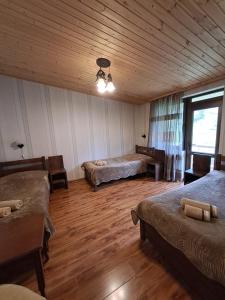 Guest House Kaldani في ميستيا: غرفة بسريرين وسقف خشبي