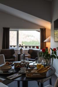 einen Tisch mit Essen und Blumen im Wohnzimmer in der Unterkunft Blåtind Boutique Hotel in Stordal