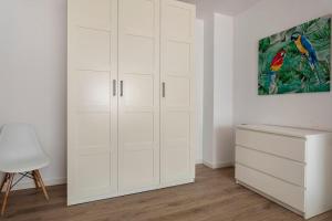 a white closet with white cabinets and a painting at Garden Turia Downtown in Valencia