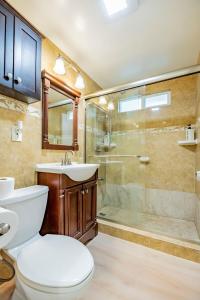 a bathroom with a toilet and a shower and a sink at Peaceful Family Home with 3 Bedrooms and 2 Bathrooms in Glendora