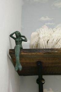una statua di una sirena seduta in un cassetto di legno di Pousada Sonho do Campo a São Pedro