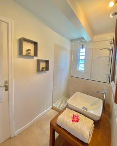 a white bathroom with a sink and a table at Habitation Bellevue in Sainte-Anne