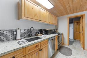 Una cocina con gabinetes de madera y un fregadero. en Creekside Suites 01 by Estes Park Condos, en Estes Park