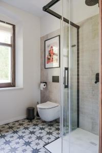 ロンデク・ズドルイにあるWilla Bywaj Zdrójのバスルーム(トイレ、ガラス張りのシャワー付)