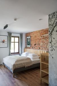 ロンデク・ズドルイにあるWilla Bywaj Zdrójのレンガの壁、ベッド付きのベッドルーム1室