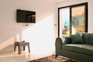 een woonkamer met een groene bank en een tv bij Dar lamisse Djerba in Houmt Souk