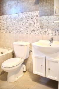 een badkamer met een wit toilet en een wastafel bij Dar lamisse Djerba in Houmt Souk