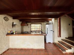 a kitchen with a white refrigerator and a counter at Valle Verde Lodge - Vista in Samaipata +12 photos