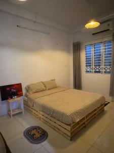een slaapkamer met een bed en een televisie. bij Paradiso in Ho Chi Minh-stad