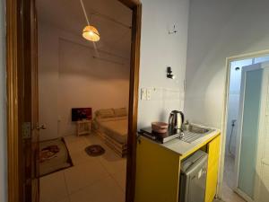 een keuken met een wastafel en een kamer met een bank bij Paradiso in Ho Chi Minh-stad
