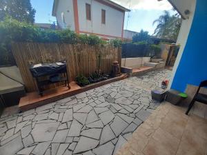 a backyard with a fence and a stone patio at L'isola del relax in Vaccarizzo - Delfino