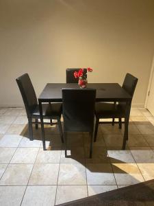 布魯克帕克的住宿－A Classy Uneic Peace，一张带椅子的黑桌和花瓶