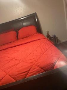 Una cama con sábanas rojas y almohadas rojas. en A Classy Uneic Peace en Brook Park