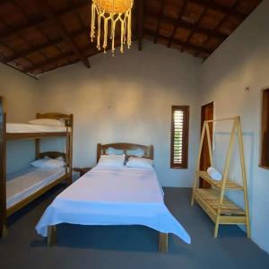 a bedroom with a bed and a chandelier at Chalé dos ventos Macapá in Ponta do Anel