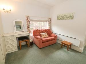 a living room with a red chair and a mirror at Rosehill Manor in Market Drayton