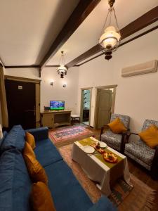 ein Wohnzimmer mit einem blauen Sofa und einem Tisch in der Unterkunft Fanizan Otel&Restaurant in Altınordu