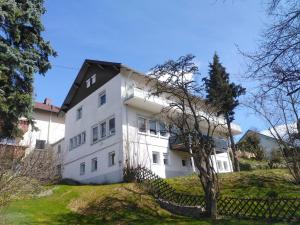 a white house with a black roof at Berghof Wörner 2 Wohnungen für bis zu 20 Personen mit Balkon I Terrasse I 4 Bäder I NETFLIX I Ruhig und gemütlich wohnen in Villingen-Schwenningen