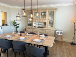 een eetkamer met een tafel met stoelen en verlichting bij Eden-Beach in Oostende
