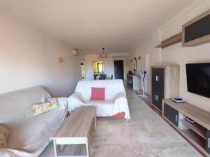 a living room with a couch and a tv at Paraíso Galera - Apartamento con piscina in Estepona