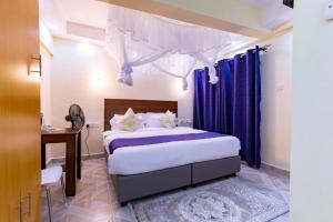 a bedroom with a bed with purple curtains at Markson Hotel Kilimani in Nairobi