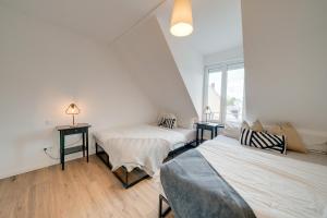 two beds in a room with a window at NEU-Luxus Apartment-Zentral 350m Altstadt-2Zi-65qm in Augsburg