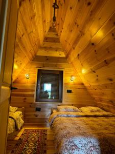 een slaapkamer met 2 bedden in een houten kamer bij Mountain house in Žabljak