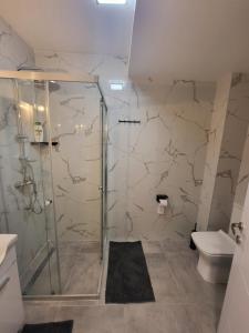 een badkamer met een douche en een toilet bij 2B Apartment in Petrovec