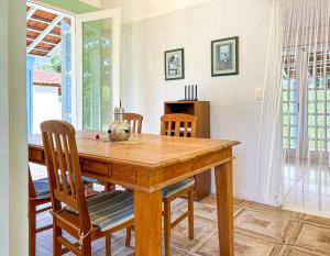 a dining room with a wooden table and chairs at Chacara com conforto e lazer em Joanopolis SP in Joanópolis