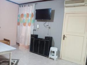 Pokój z telewizorem na ścianie i stołkiem w obiekcie Villa haydi w mieście Wadżda