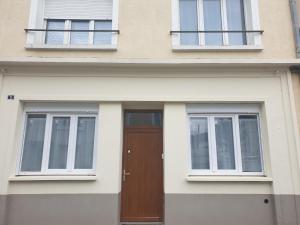 una casa con una porta marrone e due finestre di Gardenia a Villenauxe-la-Grande